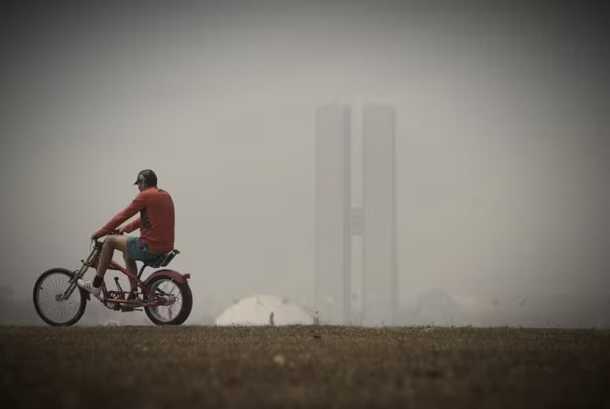 Ciclista passeia por Brasília em dia encoberto por fumaça na região (Foto: Cristiano Mariz / Agência O Globo)