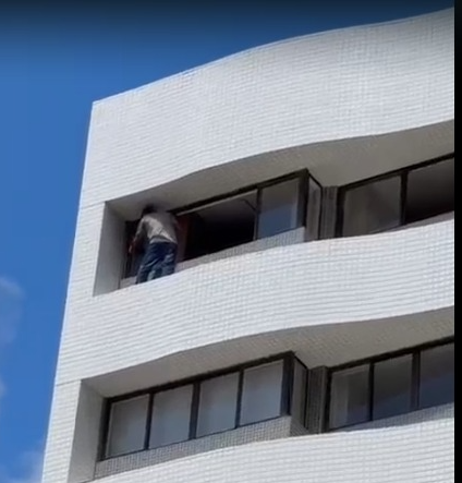 Perigo: Homem fazer serviço em cobertura de prédio sem equipamentos de segurança