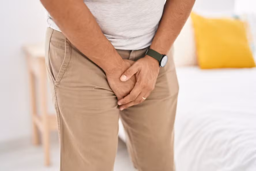 young-latin-man-covering-his-genitals-with-hands-bedroom.avif