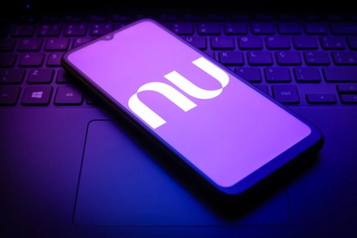 Imagem-de-telefone-celular-em-cima-de-um-teclado-de-notebook-exibindo-a-logomarca-do-Nubank.webp