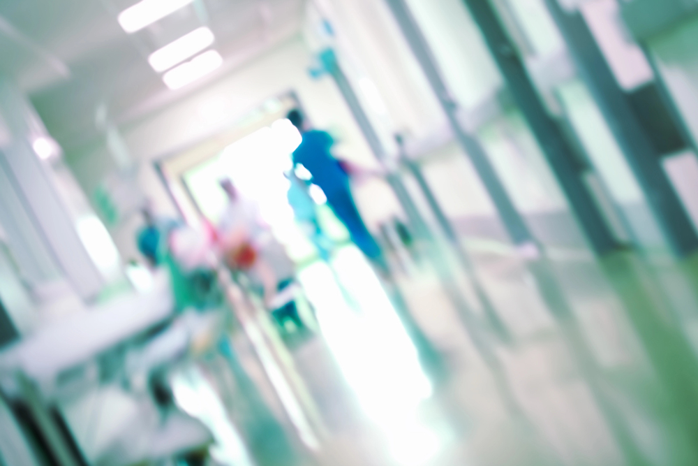 imagem-desfocada-de-corredor-de-hospital-com-profissionais-andando.jpg