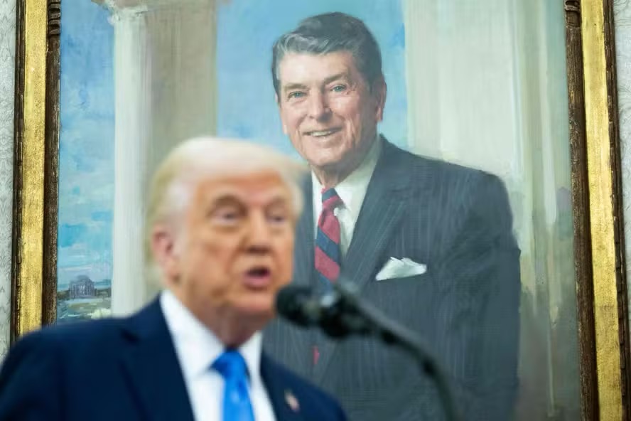 Trump discursa no salão Oval da Casa Branca em frente a um retrato de Ronald Reagan, que criticava imposição de tarifas — Foto: AFP