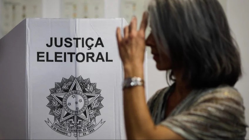eleitora à frente de urna eletrônica | PODER 360