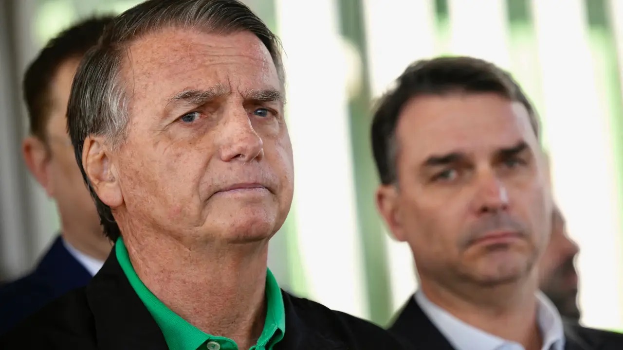 O ex-presidente Jair Bolsonaro e o filho Flávio: vigília mantida  (Mateus Bonomi/AFP)