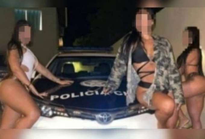 Mulheres posam de biquíni ao lado de viatura da Polícia Civil